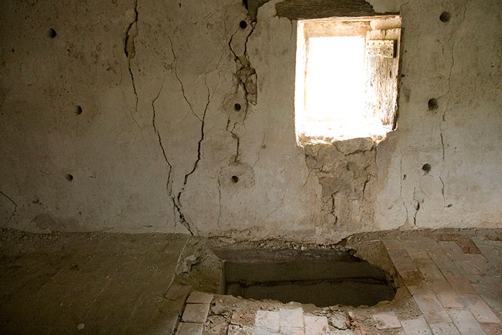 Cracks in the foundation and holes in the floor prior to revitalization